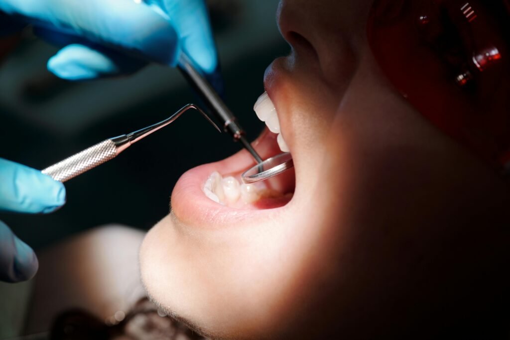 Detailed close-up of a dental check-up with tools and patient under bright light.